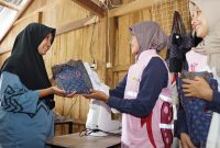 Perempuan Desa Sengkol menunjukkan hasil jahitan produk daur ulang seragam lama yang dihasilkan dari program Srikandi PLN NTB. (Foto: Dok. PLN)