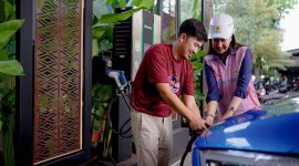 Pengguna kendaraan listrik mengisi daya di SPKLU, dengan bantuan petugas PLN yang siap melayani. (Foto: Dok. PLN)