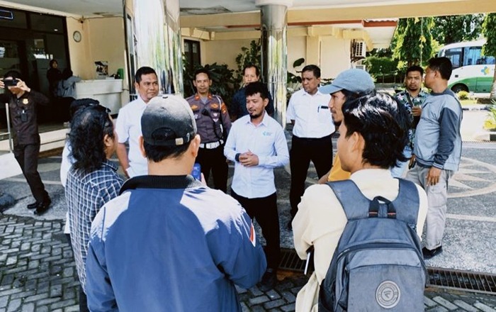 Sejumlah aktivis Forum Rakyat NTB berdiri di depan proyek gedung layanan pendidikan Poltekkes Mataram yang tampak terbengkalai, dengan material bangunan berserakan dan tanpa aktivitas konstruksi. (Foto: Istimewa)