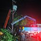 Tim teknis PLN NTB tengah memperbaiki jaringan listrik yang terdampak cuaca ekstrem di Lombok, di tengah kondisi hujan dan angin kencang. (Foto: Dok. PLN)