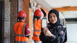 Petugas PLN memamerkan kemudahan layanan melalui aplikasi PLN Mobile saat mendampingi pekerjaan teknis di lapangan. (Foto: Dok. PLN)