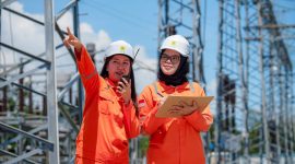 Perempuan tangguh PLN tengah berdiskusi di tengah instalasi listrik tegangan tinggi, menggambarkan kiprah perempuan yang kini memimpin perubahan dalam industri energi. (Foto: Dok. PLN)