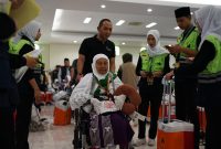 Petugas dengan sigap mendampingi jemaah haji lanjut usia saat proses pemberangkatan di Asrama Haji Embarkasi Lombok, Jumat (16/8/2024). Layanan khusus terus dioptimalkan demi memastikan kenyamanan dan keselamatan jemaah haji NTB, termasuk bagi lansia dan penyandang disabilitas. (Foto: Istimewa)