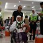Petugas dengan sigap mendampingi jemaah haji lanjut usia saat proses pemberangkatan di Asrama Haji Embarkasi Lombok, Jumat (16/8/2024). Layanan khusus terus dioptimalkan demi memastikan kenyamanan dan keselamatan jemaah haji NTB, termasuk bagi lansia dan penyandang disabilitas. (Foto: Istimewa)