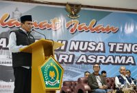 Kepala Kantor Wilayah Kementerian Agama Provinsi NTB, H. Zamroni Aziz, saat memberikan sambutan dalam pelepasan jamaah haji Kloter 1 asal Lombok Barat di Asrama Haji NTB. Ia berpesan agar jamaah menjaga kesehatan dan kekompakan selama menjalani ibadah di Tanah Suci. (Foto: Istimewa)