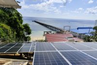 Pembangkit Listrik Tenaga Surya (PLTS) di kawasan pesisir dengan latar dermaga dan laut lepas. Pemanfaatan energi terbarukan ini menjadi bagian dari upaya penyediaan listrik ramah lingkungan di wilayah kepulauan dan pesisir Indonesia. (Dok. PLN)