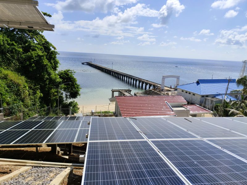 Pembangkit Listrik Tenaga Surya (PLTS) di kawasan pesisir dengan latar dermaga dan laut lepas. Pemanfaatan energi terbarukan ini menjadi bagian dari upaya penyediaan listrik ramah lingkungan di wilayah kepulauan dan pesisir Indonesia. (Dok. PLN)