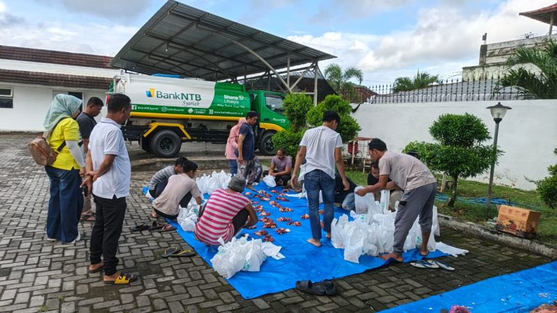 Sejumlah relawan tengah membagi dan mengemas daging kurban di halaman kantor dengan latar belakang mobil operasional Bank NTB Syariah. Kegiatan ini mencerminkan komitmen lembaga dalam mendukung distribusi daging kurban secara merata kepada masyarakat. (Foto: Istimewa)