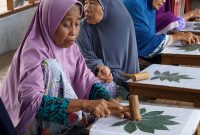 Para lansia di Desa Jenggik mengikuti pelatihan keterampilan membatik daun sebagai bagian dari program pembelajaran lintas generasi di Eco School Lentera yang didukung PLN.  (Foto: Dok. PLN)