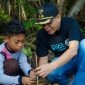 Seorang anak dibimbing oleh perwakilan pemerintah saat menanam bibit mangrove di kawasan ekowisata Bale Mangrove, Jerowaru, Lombok Timur. Aksi ini menjadi bagian dari peringatan Hari Mangrove Sedunia dan wujud nyata edukasi lingkungan kepada generasi muda dalam program pemberdayaan desa berbasis konservasi yang didukung PLN. (Foto: Dok. PLN)