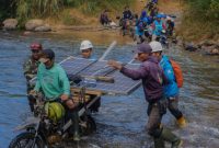 pekerja mengangkut panel surya menyeberangi sungai,
Upaya PLN menghadirkan listrik hingga pelosok negeri distribusi panel surya ke wilayah terpencil. (Foto: Dok. PLN)