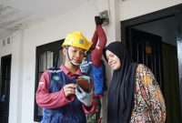 Petugas PLN memberikan edukasi keselamatan dan penggunaan layanan digital kepada pelanggan saat melakukan pengecekan instalasi listrik di rumah. (Foto: Dok. PLN)