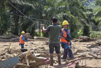PLN dan masyarakat bergotong royong memulihkan jaringan listrik di tengah sisa material banjir. (Dok. PLN)
