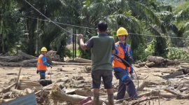 PLN dan masyarakat bergotong royong memulihkan jaringan listrik di tengah sisa material banjir. (Dok. PLN)