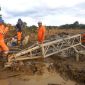 Tim PLN bekerja di tengah lumpur tebal untuk membangun ulang struktur tower dan memperbaiki jaringan transmisi yang terdampak banjir. (Dok. PLN)