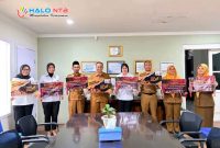 Jajaran pejabat dan pegawai Pemerintah Daerah berfoto bersama usai kegiatan sosialisasi pencegahan kekerasan terhadap perempuan dan anak sambil memegang poster kampanye edukatif di ruang rapat kantor pemerintahan.(Foto: Diskominfotik NTB)