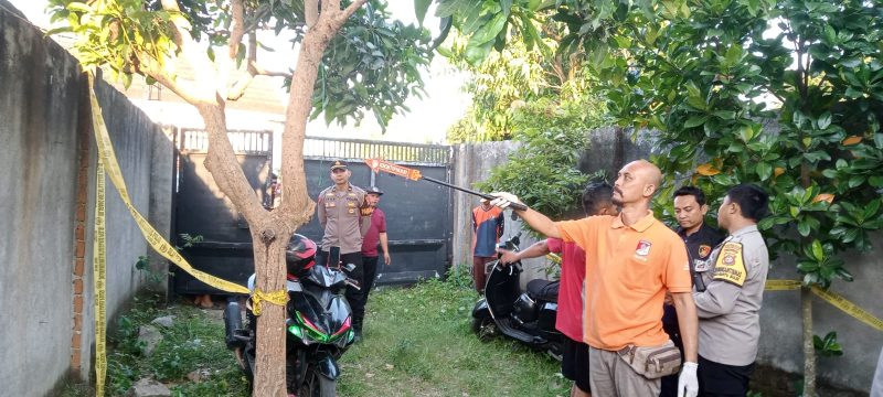 Petugas kepolisian saat melakukan olah TKP di lokasi penemuan jenazah pria yang tergantung di pohon mangga di Banyumulek, Lombok Barat.(Foto: Istimewa)