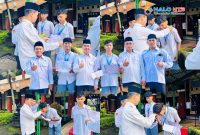 Kepala MAN Lombok Barat menyerahkan penghargaan kepada dua siswa berprestasi usai upacara bendera di halaman madrasah.(Foto: Istimewa)