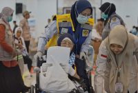 Petugas haji membantu jemaah lanjut usia saat proses pemberangkatan di Embarkasi Lombok, memastikan pelayanan dan pendampingan berjalan optimal.(Foto.Istimewa)