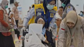 Petugas haji membantu jemaah lanjut usia saat proses pemberangkatan di Embarkasi Lombok, memastikan pelayanan dan pendampingan berjalan optimal.(Foto.Istimewa)