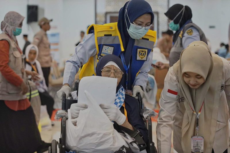 Petugas haji membantu jemaah lanjut usia saat proses pemberangkatan di Embarkasi Lombok, memastikan pelayanan dan pendampingan berjalan optimal.(Foto.Istimewa)