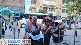Petugas PPIH menyambut dan membantu Jemaah Haji Kloter 3 asal Lombok Barat saat tiba di Asrama Haji Mataram usai menunaikan ibadah haji di Tanah Suci, Kamis (4/6/2026). (Foto: Istimewa)