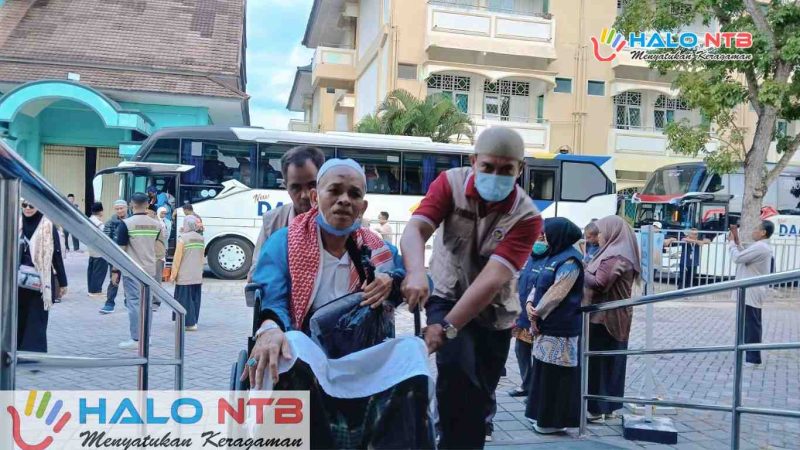 Petugas PPIH menyambut dan membantu Jemaah Haji Kloter 3 asal Lombok Barat saat tiba di Asrama Haji Mataram usai menunaikan ibadah haji di Tanah Suci, Kamis (4/6/2026). (Foto: Istimewa)