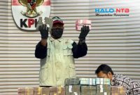Petugas KPK menunjukkan barang bukti uang dalam konferensi pers Operasi Tangkap Tangan (OTT) Bupati Lombok Barat Lalu Ahmad Zaini di Gedung Merah Putih KPK, Jakarta, Selasa (21/7).