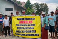 Sejumlah warga pemilik kavling membentangkan spanduk bertuliskan penolakan terhadap penggunaan jalan kavlingan untuk akses proyek perumahan yang dikembangkan PT Lambang Sejati. (Foto: Istimewa)