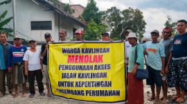 Sejumlah warga pemilik kavling membentangkan spanduk bertuliskan penolakan terhadap penggunaan jalan kavlingan untuk akses proyek perumahan yang dikembangkan PT Lambang Sejati. (Foto: Istimewa)