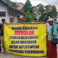 Sejumlah warga pemilik kavling membentangkan spanduk bertuliskan penolakan terhadap penggunaan jalan kavlingan untuk akses proyek perumahan yang dikembangkan PT Lambang Sejati. (Foto: Istimewa)