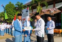 Kepala MAN Lombok Barat, H. Kemas Burhan, didampingi Waka Humas, menyerahkan secara simbolis beasiswa Komite Madrasah kepada Ketua dan Wakil Ketua ORSIMA terpilih periode 2026–2027, Hasbi Al Hafiz dan Kayla Fatimatuzzahra, di halaman MAN Lombok Barat.(Foto: Istimewa)