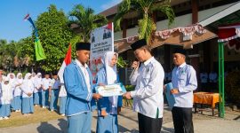 Kepala MAN Lombok Barat, H. Kemas Burhan, didampingi Waka Humas, menyerahkan secara simbolis beasiswa Komite Madrasah kepada Ketua dan Wakil Ketua ORSIMA terpilih periode 2026–2027, Hasbi Al Hafiz dan Kayla Fatimatuzzahra, di halaman MAN Lombok Barat.(Foto: Istimewa)