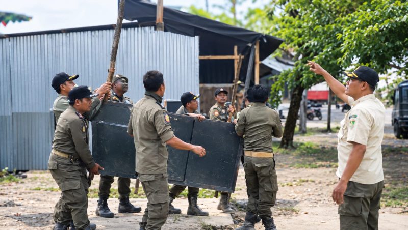Sejumlah petugas Satpol PP Lombok Barat bergotong royong mengangkat rombong milik pedagang kaki lima yang ditertibkan karena berjualan di ruang publik.(Foto: Istimewa)