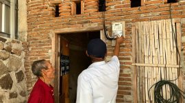 Caption: Petugas PLN memastikan sambungan listrik di rumah warga telah terpasang sebagai bagian dari program kepedulian YBM PLN.(Foto: Istimewa 