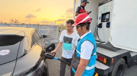 Petugas PLN mendampingi pengguna kendaraan listrik saat melakukan pengisian daya di kawasan Mandalika.